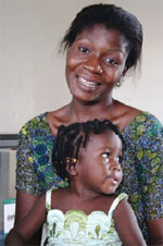 健康な子どもを抱いてすてきな笑顔を見せる母親。IBMの企業ボランティアは、保健医療をナイジェリアでの活動目標に選んだ (courtesy of IBM)